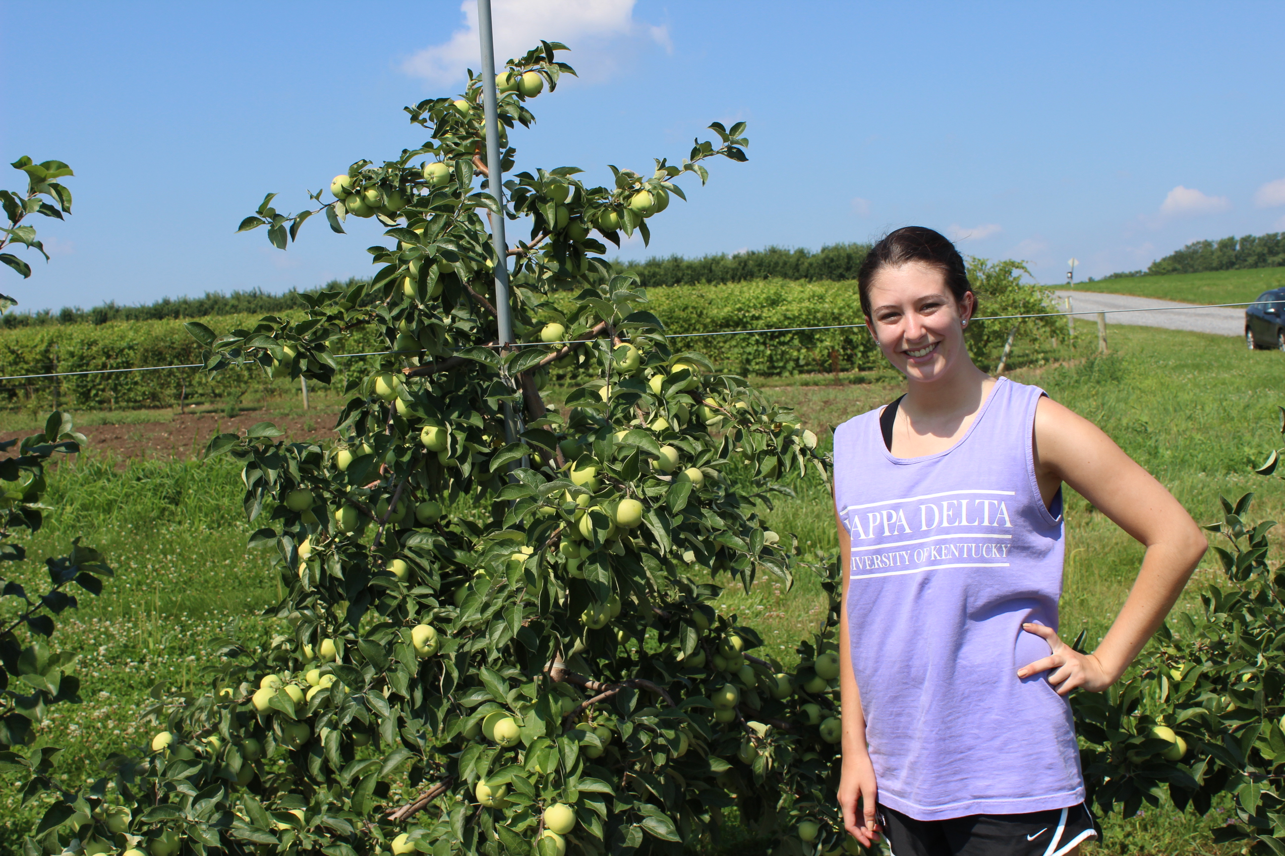 Devin Henry with an apple tree, the focus of her summer studies. 