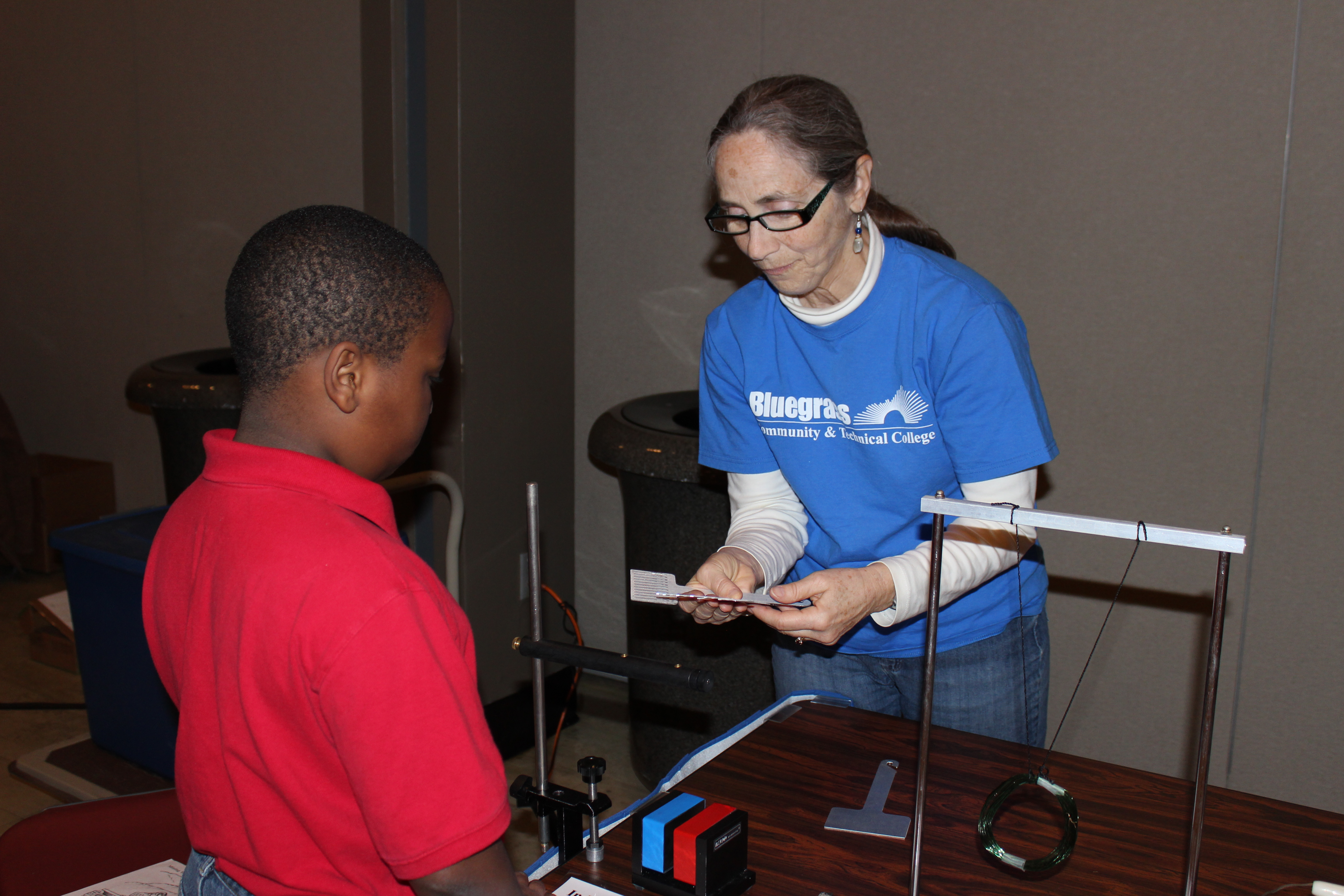 A representative from Bluegrass Community and Technical College works with one of the elementary students at the Energy Fair Dec. 9 in the UK Student Center Grand Ballroom.