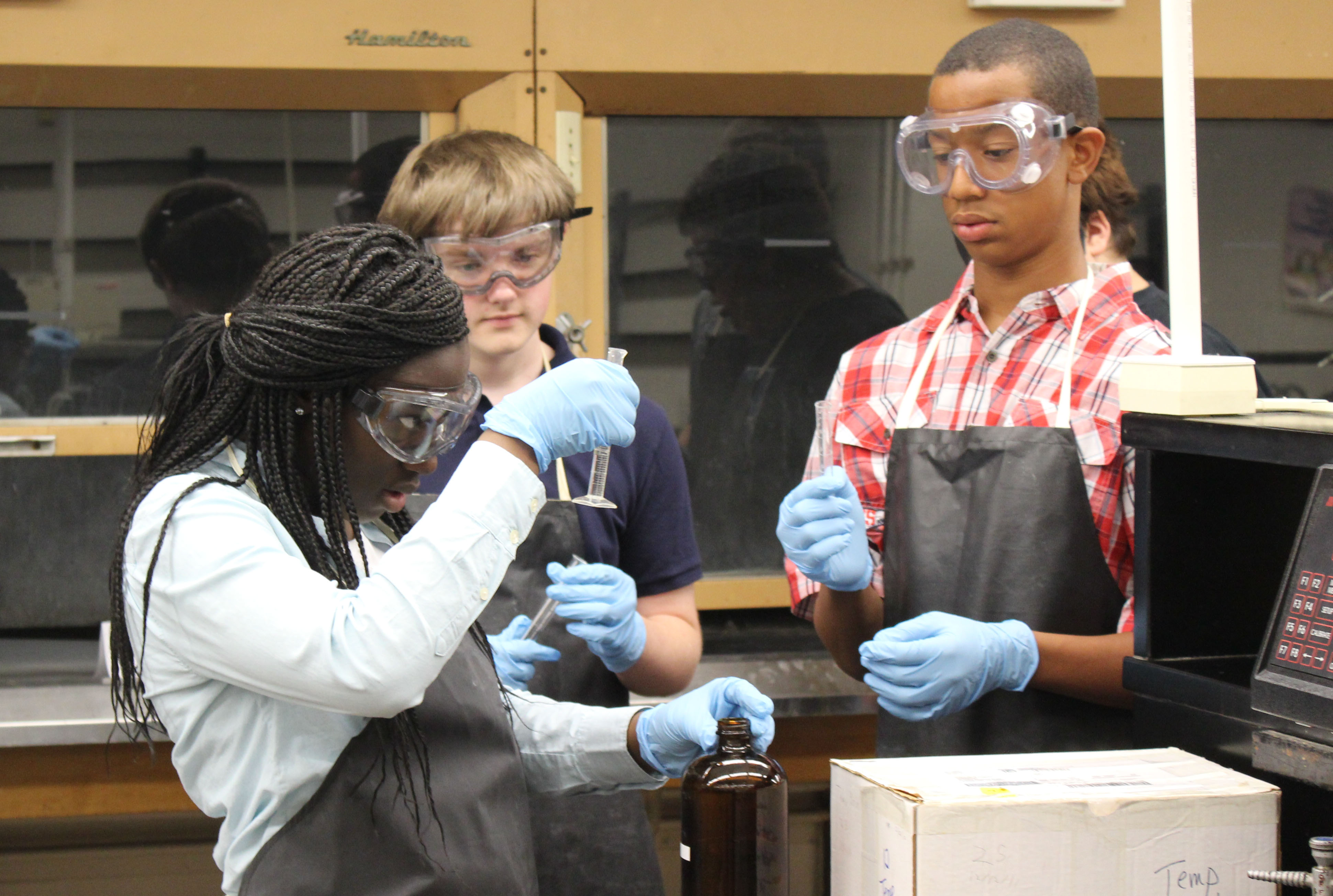 Stephanie Bamfo (left) conducts a chemistry experiment with her fellow STEAM Academy students at UK.